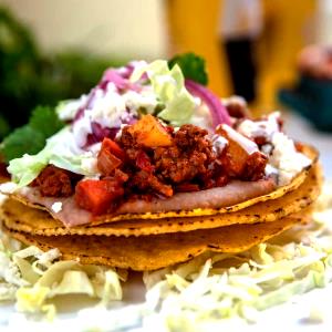 Quantas calorias em 1 Oz Taco ou Tostada com Feijões, Queijo, Carne, Alface, Tomate e Salsa?