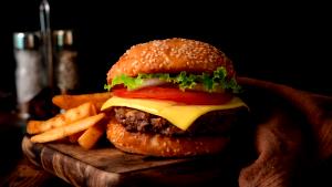 Quantas calorias em 1 Porção Sanduíche hambúrguer bovino grelhado (com pão hambúrguer) com alface e tomate?