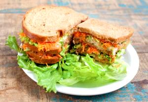 Quantas calorias em 1 Porção Sanduíche pão forma integral com peito de frango grelhado alface americana cenoura crua tomate e molho de iogurte?
