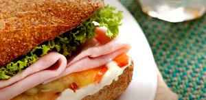 Quantas calorias em 1 Porção Sanduíche pão francês com presunto queijo muçarela e cream cheese?