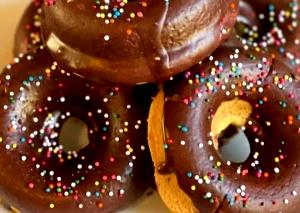 Quantas calorias em 100 G Donuts Cobertos com Chocolate?
